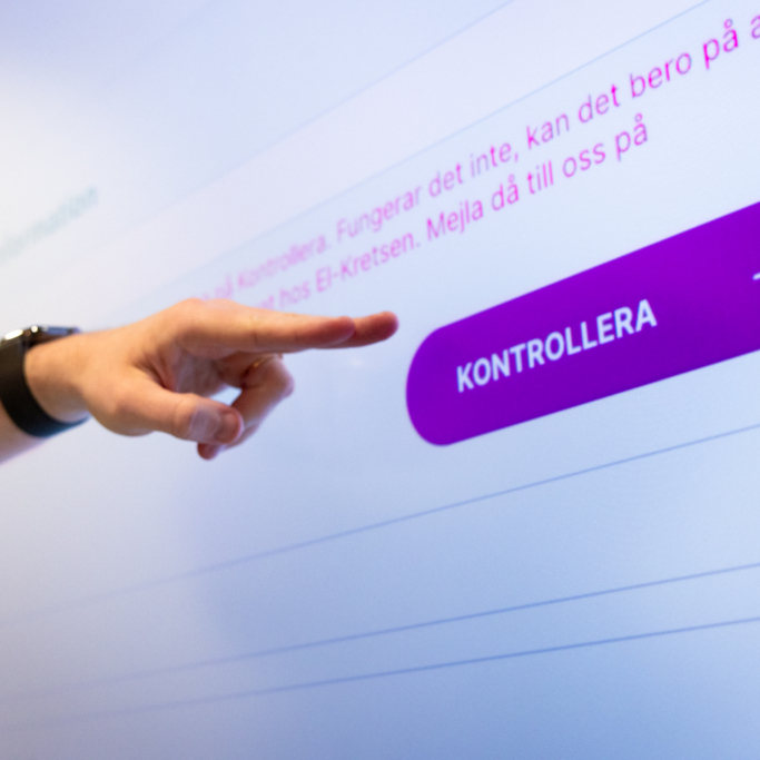 Hand som pekar på skärm med hemsida och knappar.